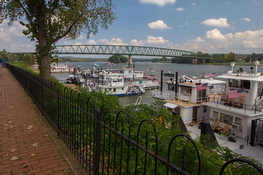 Marietta, OH Insurance - Boats Docked on the River, Seen From a Brick Pathway With Wrought Iron Fencing